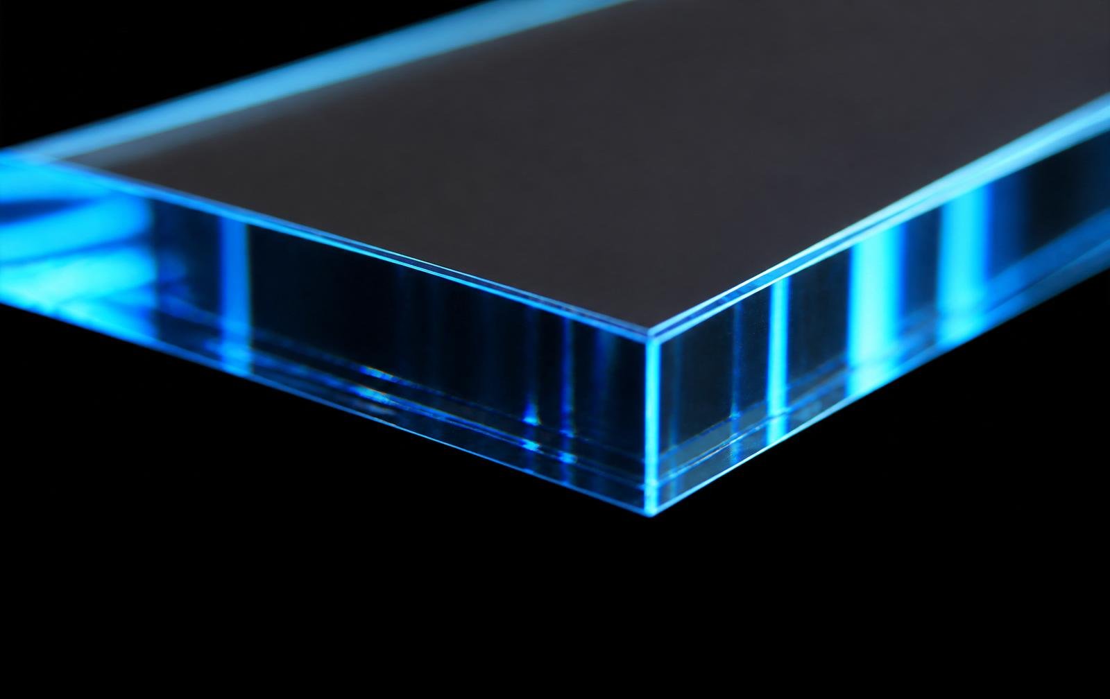Macro close-up of a clean laser-cut edge on a transparent acrylic sheet, showing crystal clarity